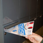 A toolsforfools ma iling brochure is being pushed into a mailbox.